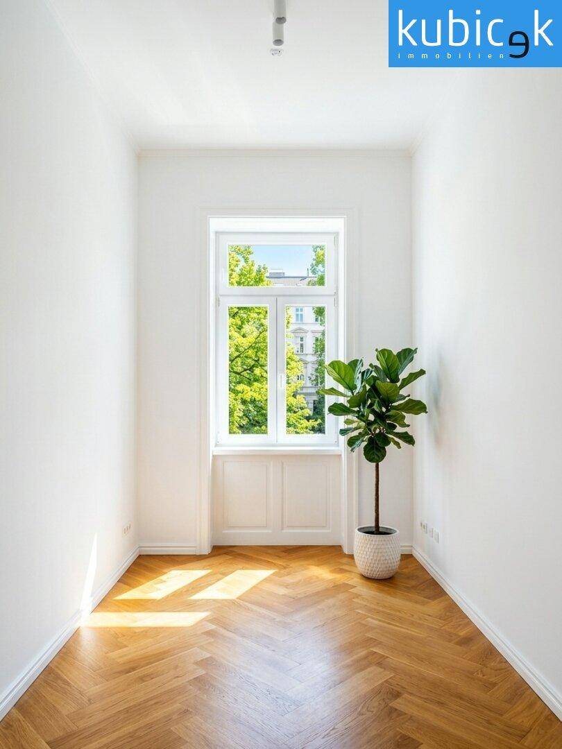 Schmales Zimmer mit Fischgrätparkett, einem großen Fenster und viel natürlichem Licht.