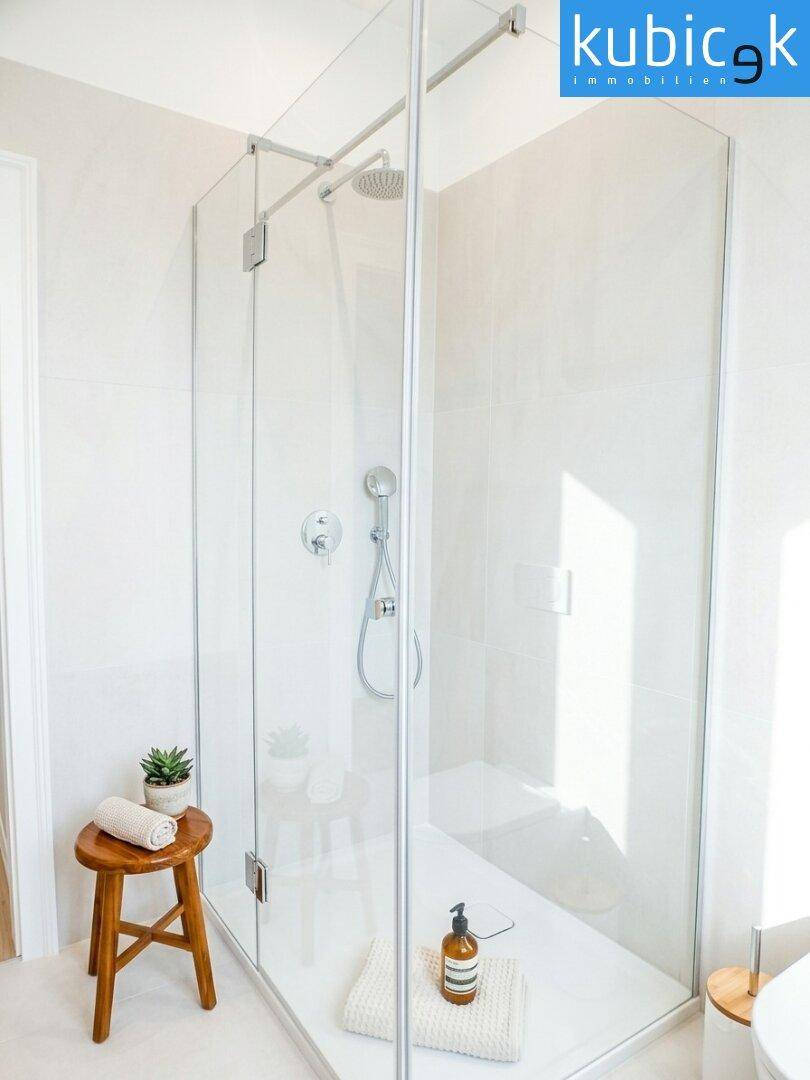 Geräumige, moderne Walk-in-Dusche mit Glasabtrennung und Regenduschkopf für ein luxuriöses Duscherlebnis.