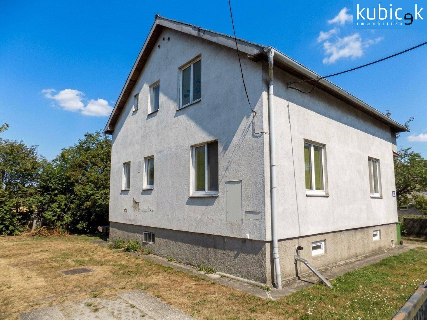 Rückansicht des Einfamilienhauses mit schlichter Fassade und Fenstern im Obergeschoss.
