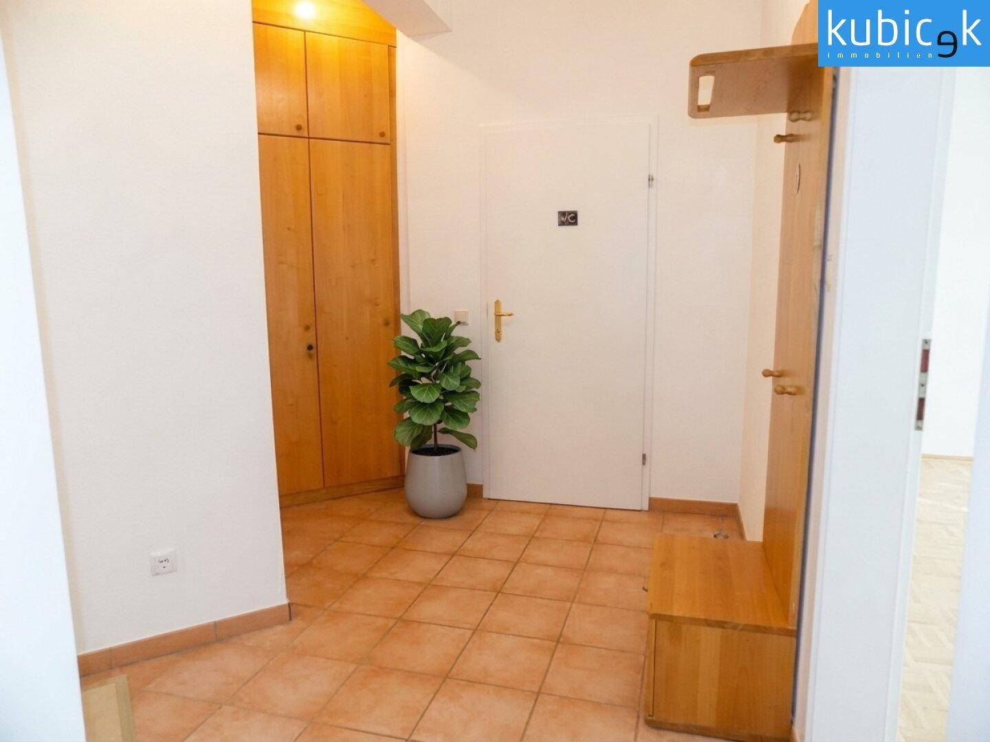 Flur mit Terrakotta-Fliesen, Garderobe und Einbauschrank.