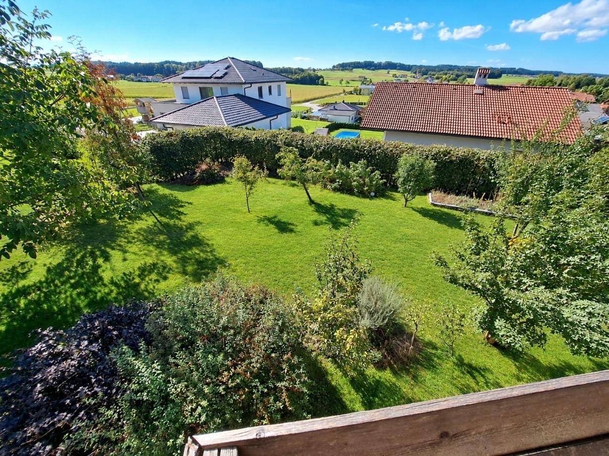 Panoramablick über den gepflegten Garten und die umliegende grüne Landschaft.