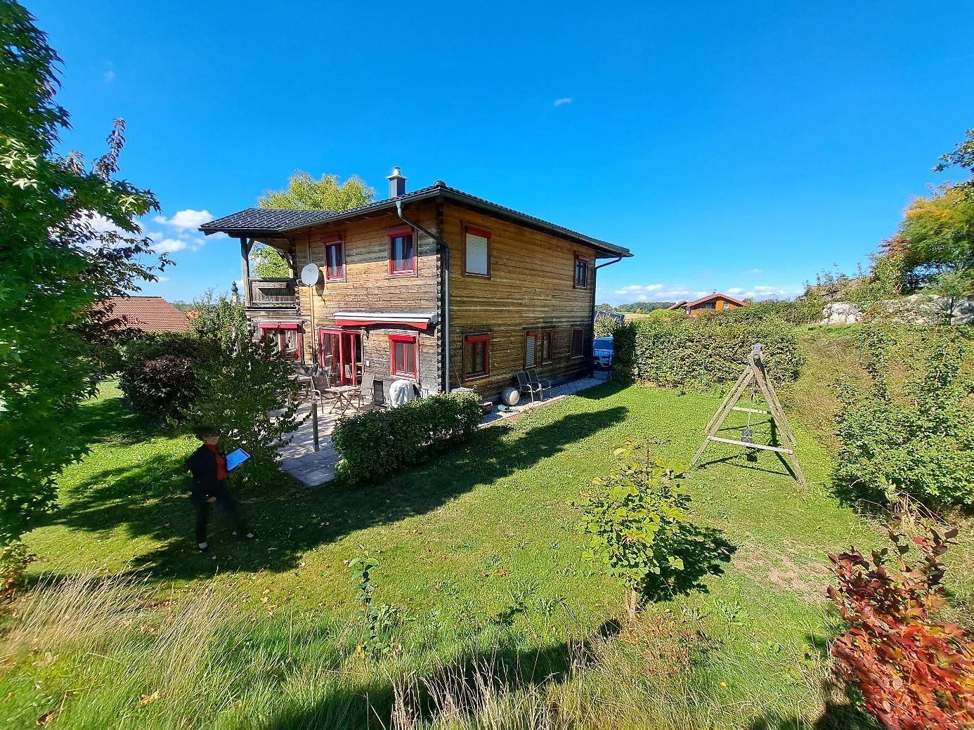 Weitläufiger Garten mit Rasenfläche und Holzhaus, ideal für Familienaktivitäten im Freien.