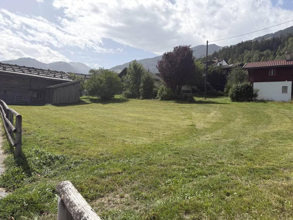 Weitläufiges Grundstück mit Wiesenfläche und Panoramablick auf die Berge.