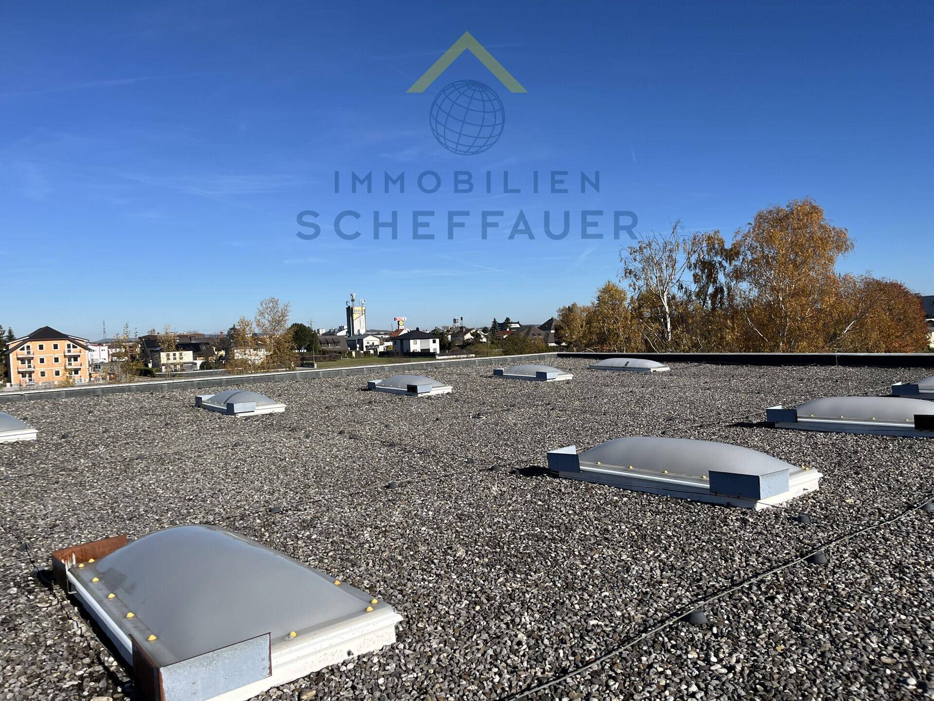 Flachdach mit Kiesbedeckung und Oberlichtern, bietet einen weiten Blick auf die Umgebung.