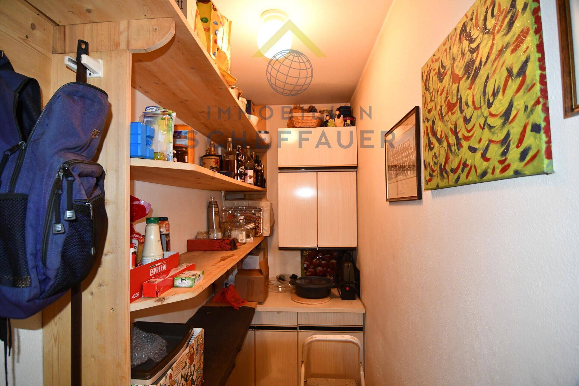 Praktische Speisekammer mit offenen Holzregalen und Stauraum für diverse Vorräte.