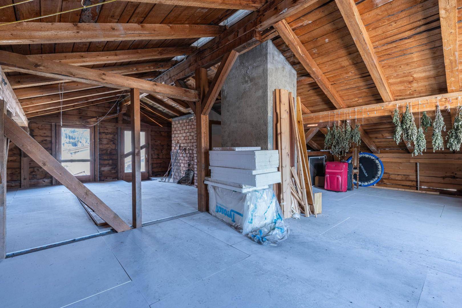 Unausgebauter Dachboden mit Holzbalken und viel Stauraum, bietet Potenzial für zukünftige Nutzung.