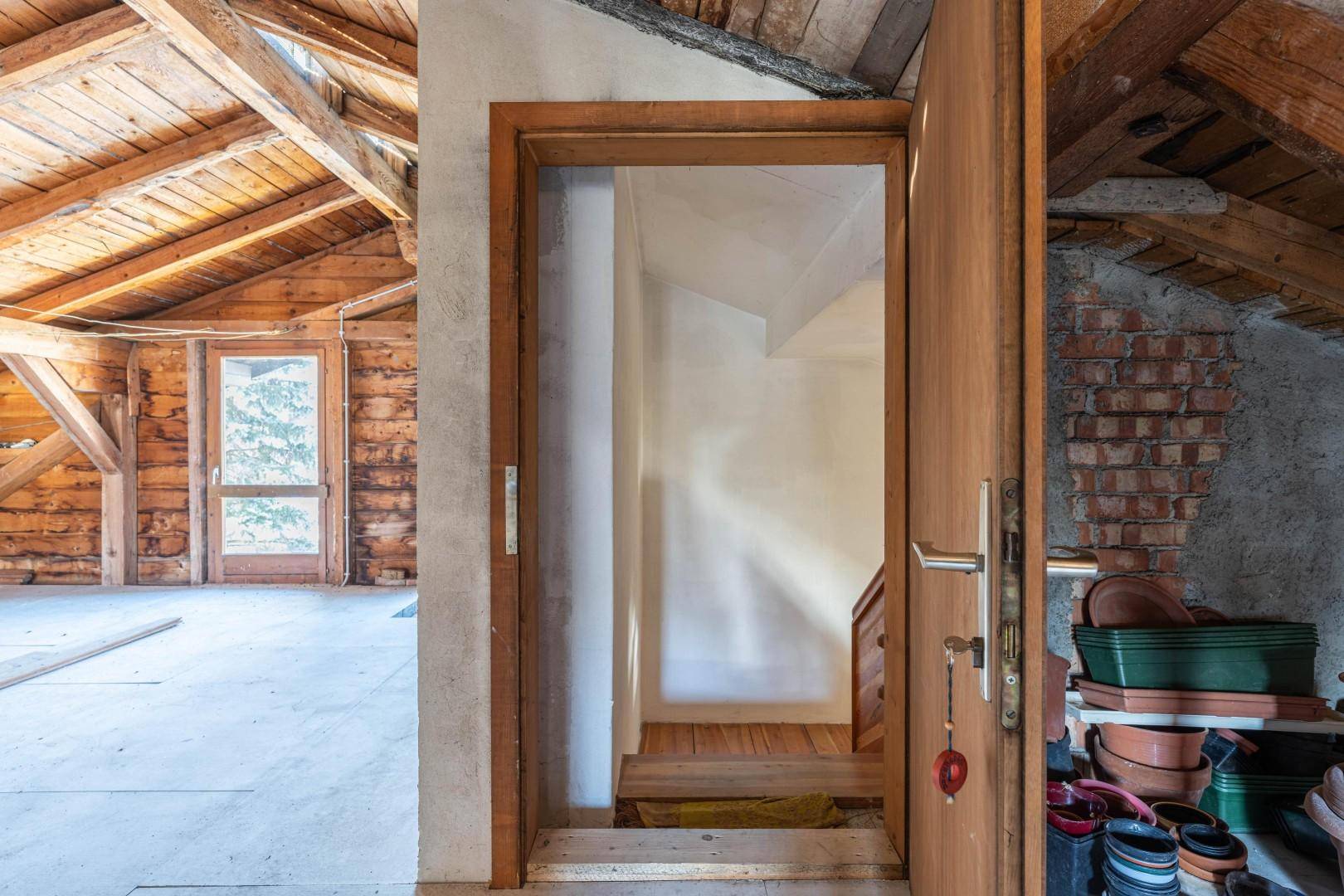 Dachbodenbereich mit Holzbalken und Zugang zur Treppe, bietet Raum für Erweiterung.