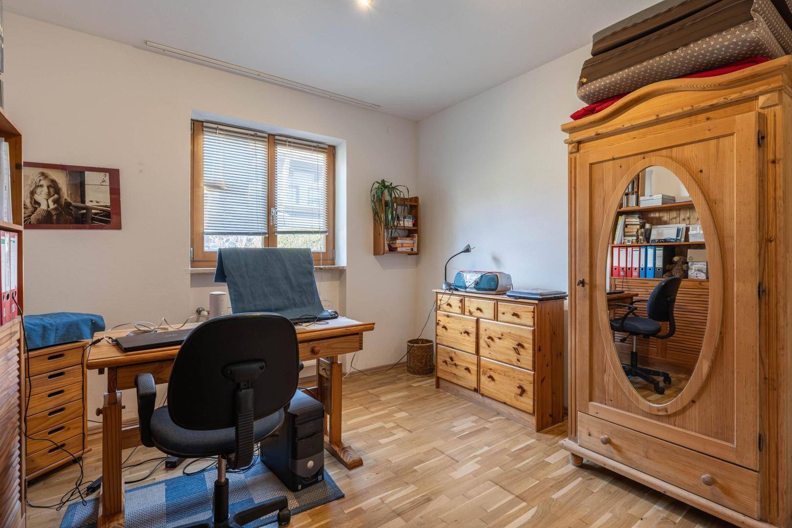 Funktionales Arbeitszimmer mit Holzboden und Holzmöbeln, ausgestattet für produktives Arbeiten.