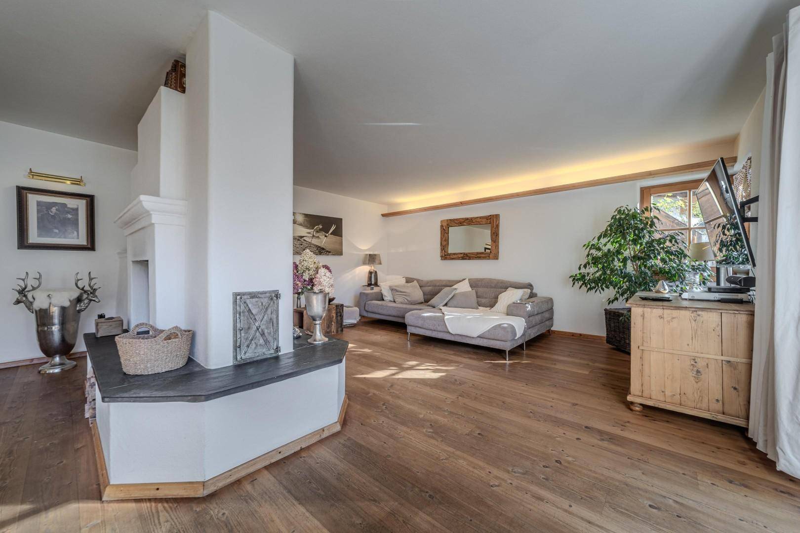 Gemütliches Wohnzimmer mit Holzboden, Kamin und bequemer Couch, ideal zum Entspannen.
