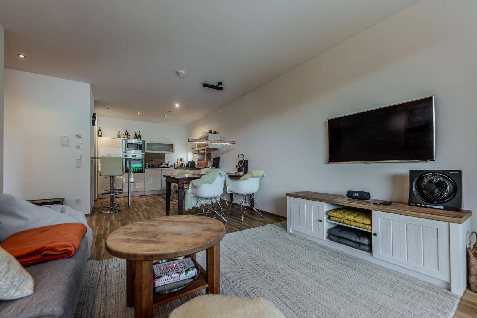 Heller offener Wohn-Essbereich mit integrierter Küche und modernem Interieur.