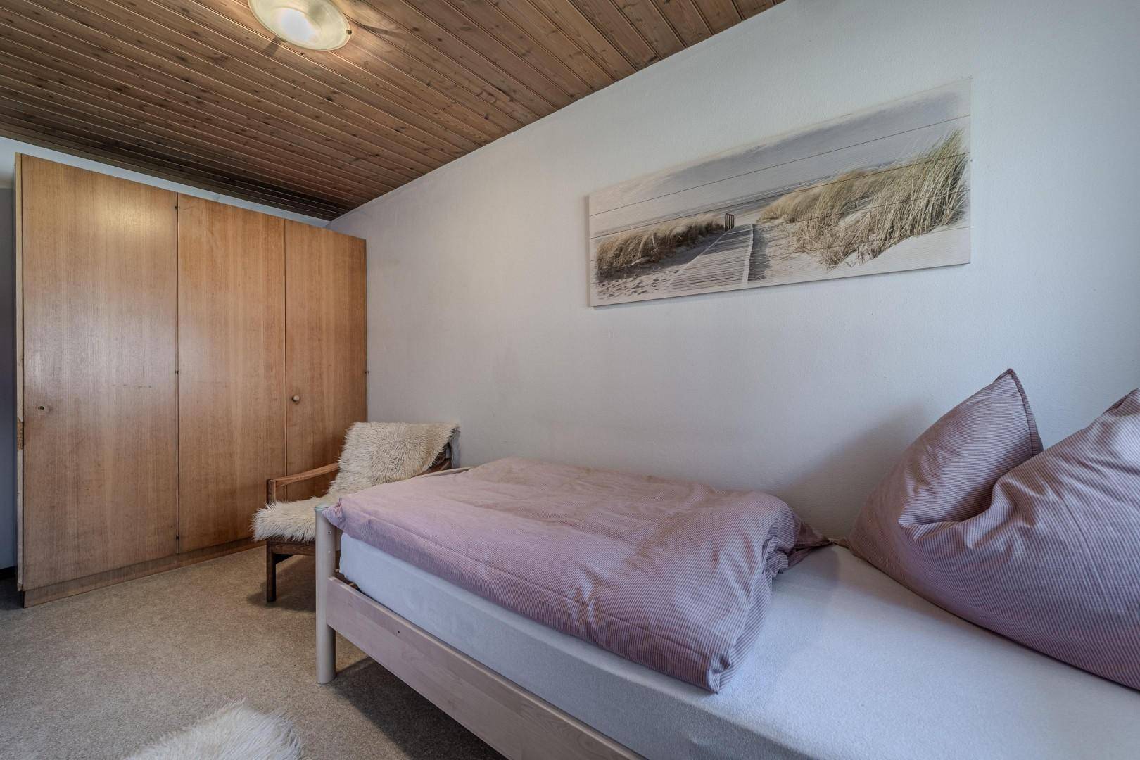 Schlafzimmer mit Einbauschrank, Holzdecke und gemütlicher Atmosphäre.