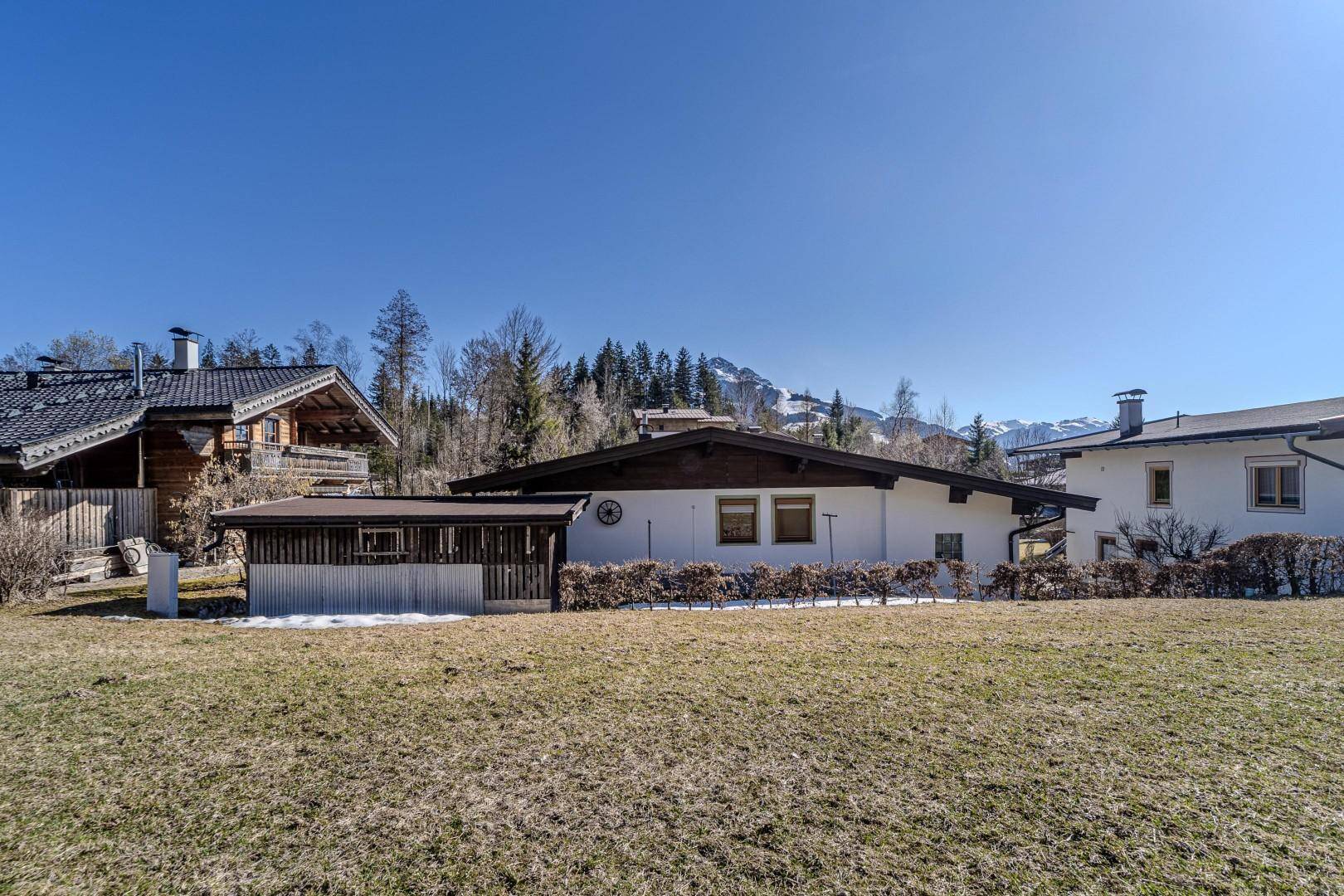 Rückansicht des Hauses mit Nebengebäude und weitem Blick auf die schneebedeckten Berge.