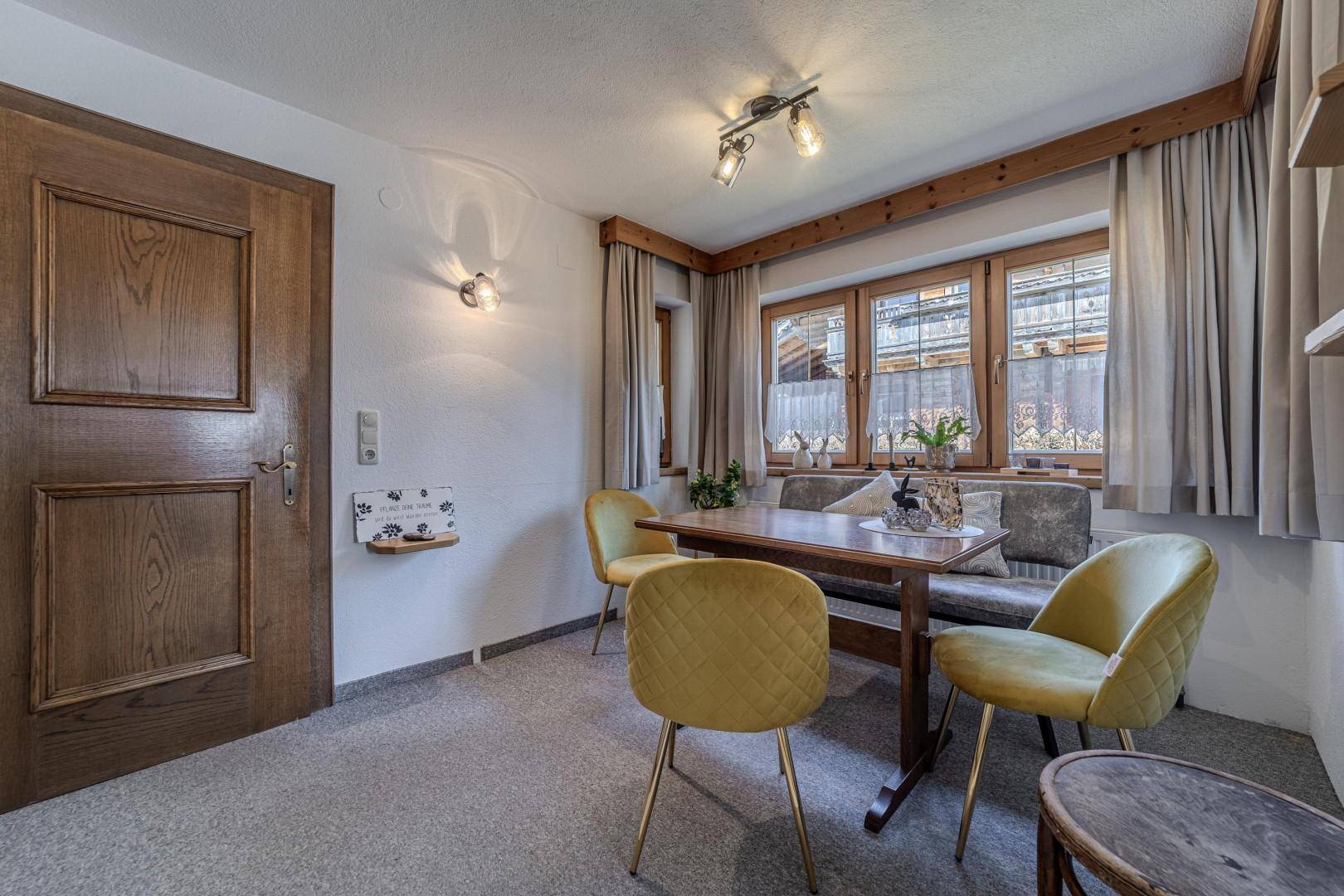 Esszimmer mit Holztür, Fensterfront und Teppichboden, ideal für Familienmahlzeiten.