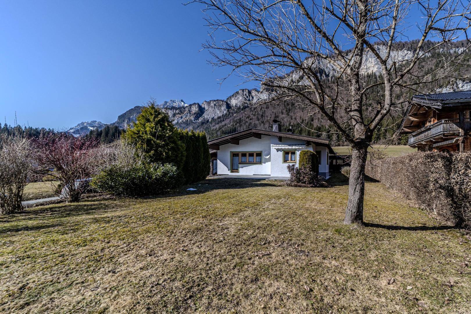 Freistehendes Haus mit großem Rasen und Bergblick in einer ruhigen alpinen Umgebung.