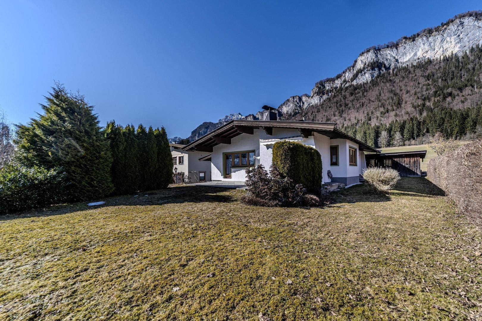 Charmantes Haus mit gepflegtem Gartenbereich und beeindruckendem Blick auf die umliegenden Berge.