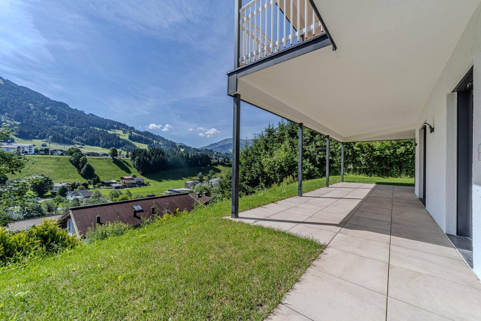 Weitläufige Terrasse mit Rasen und atemberaubendem Panoramablick auf die Berge.