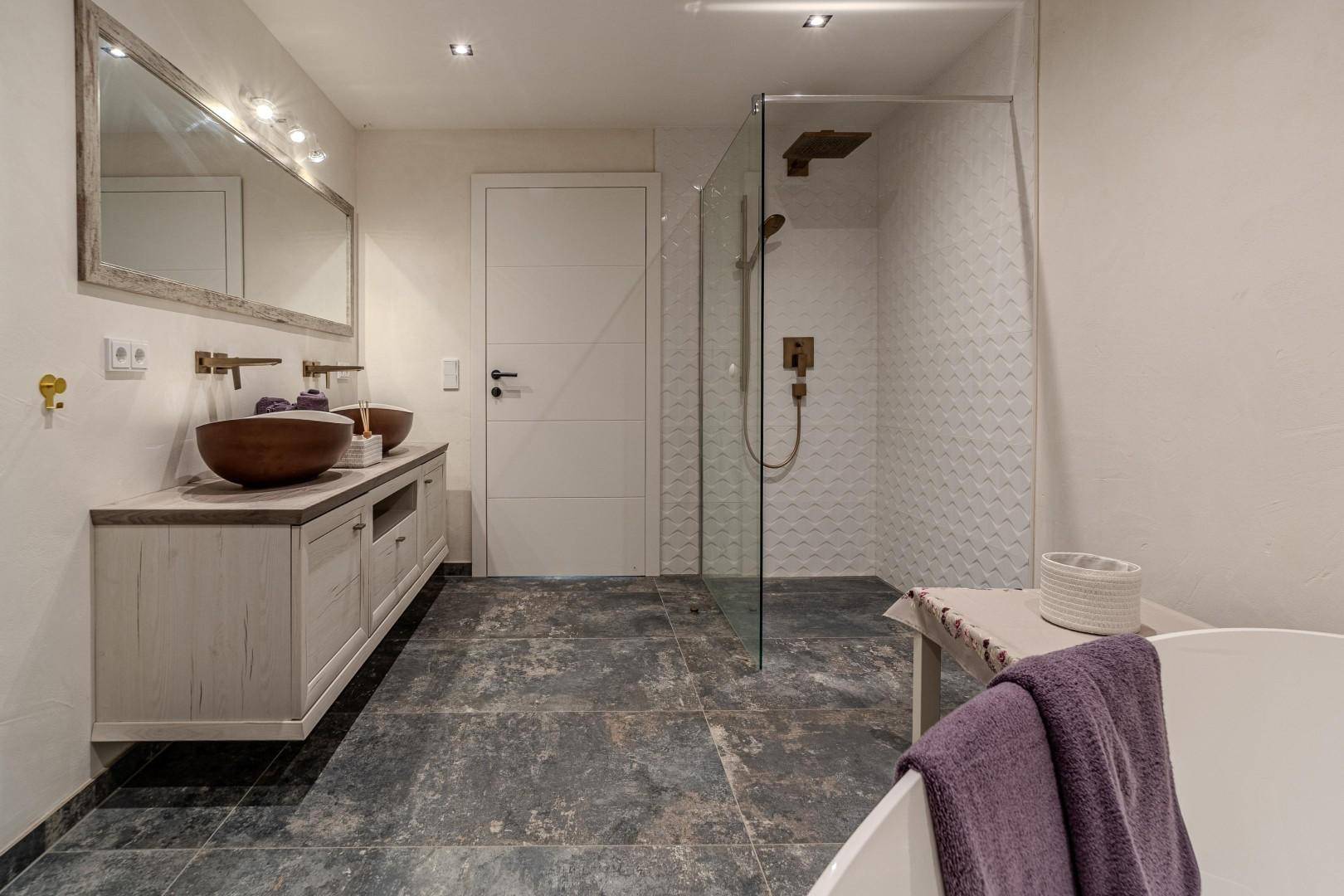 Elegantes Badezimmer mit begehbarer Dusche, freistehender Wanne und Doppelwaschbecken.