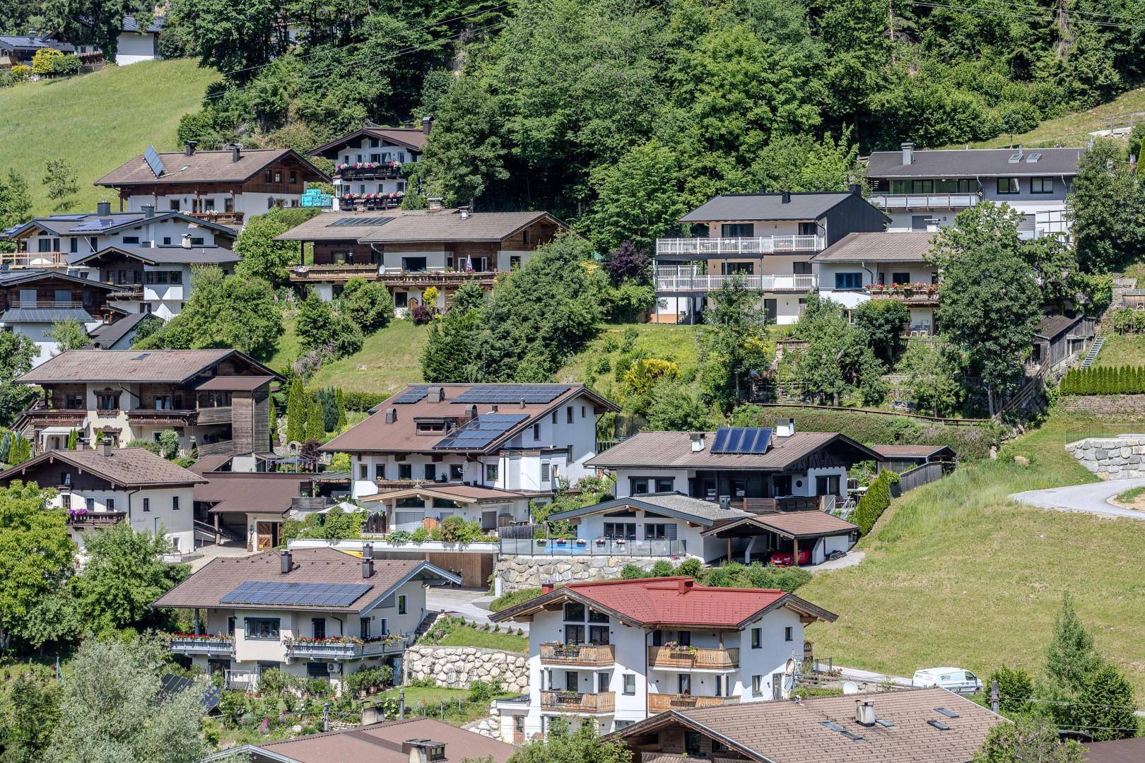 Malerische Ansicht von Häusern am Hang mit üppiger Vegetation und Bergblick.