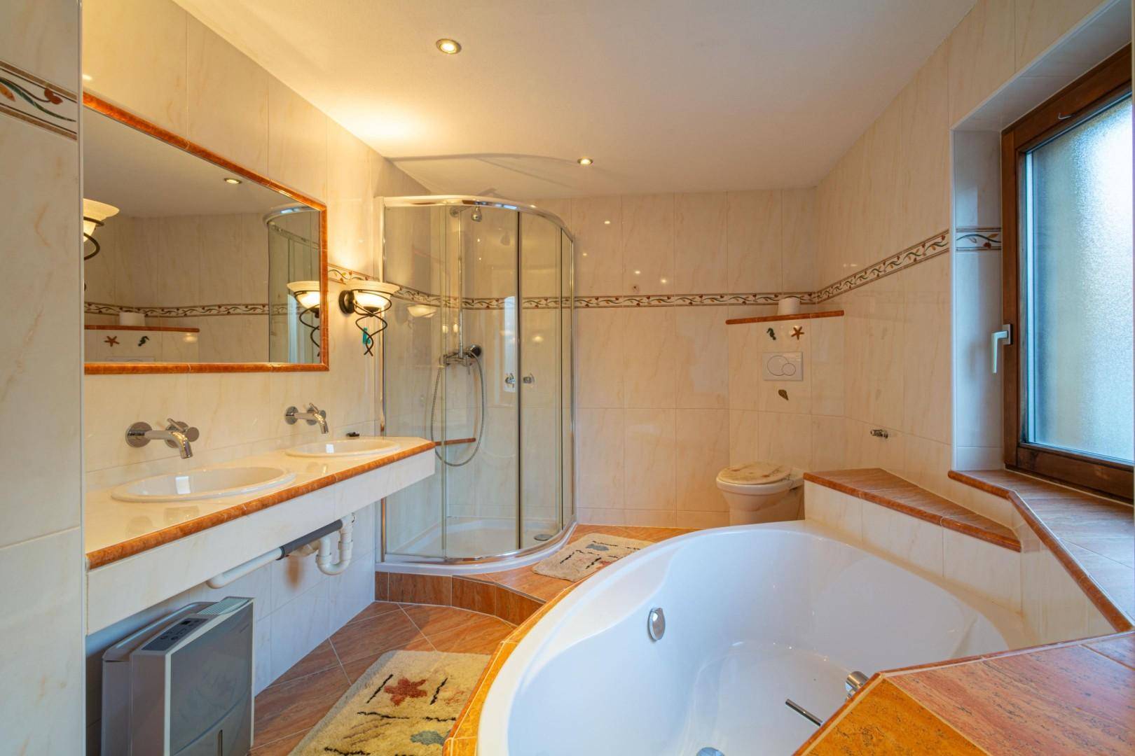 Modernes Badezimmer mit Doppelwaschbecken, Duschkabine, Eckbadewanne und Fenster.