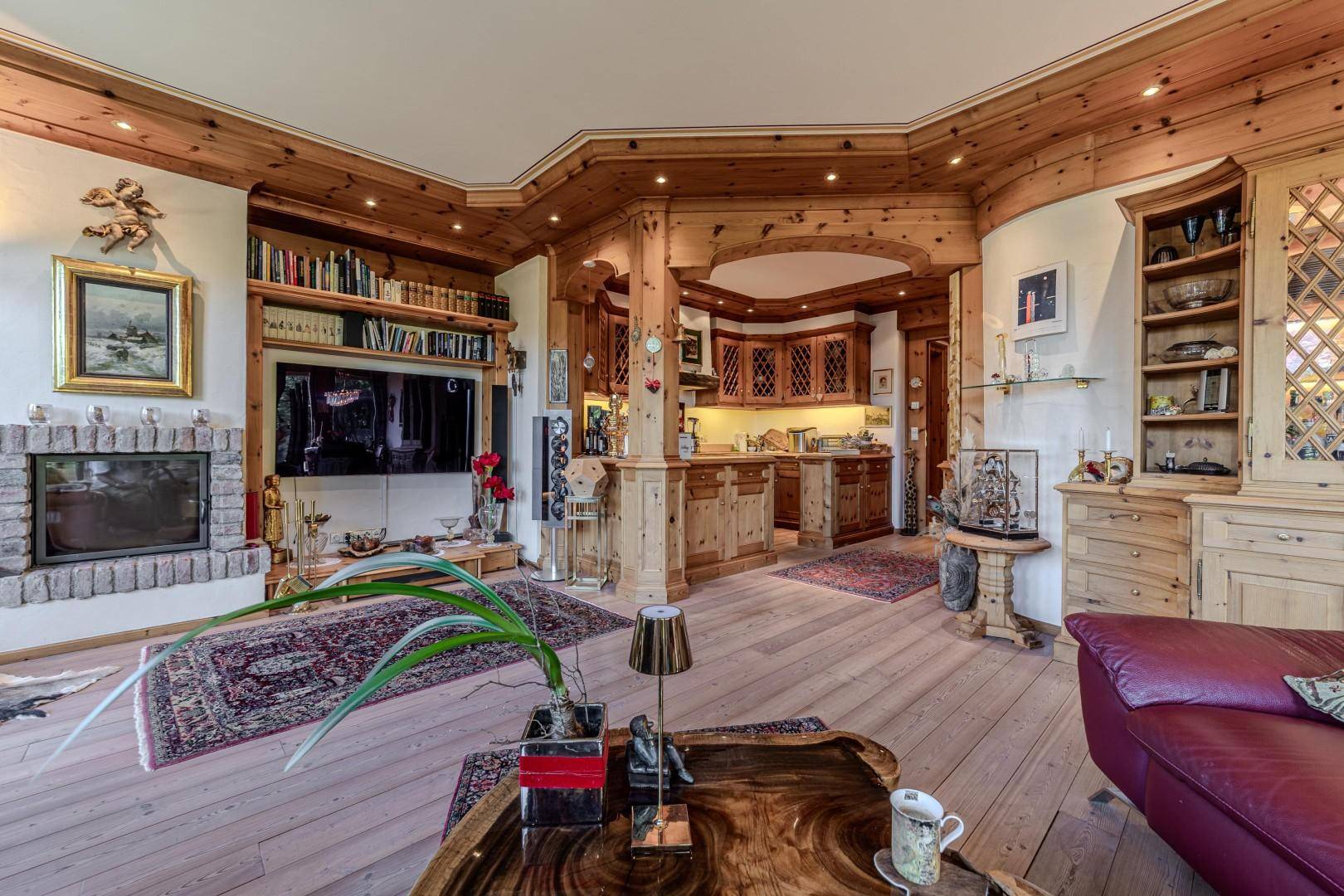 Offener Wohnbereich mit Kamin, Holzböden und angrenzender Küche im traditionellen Stil.