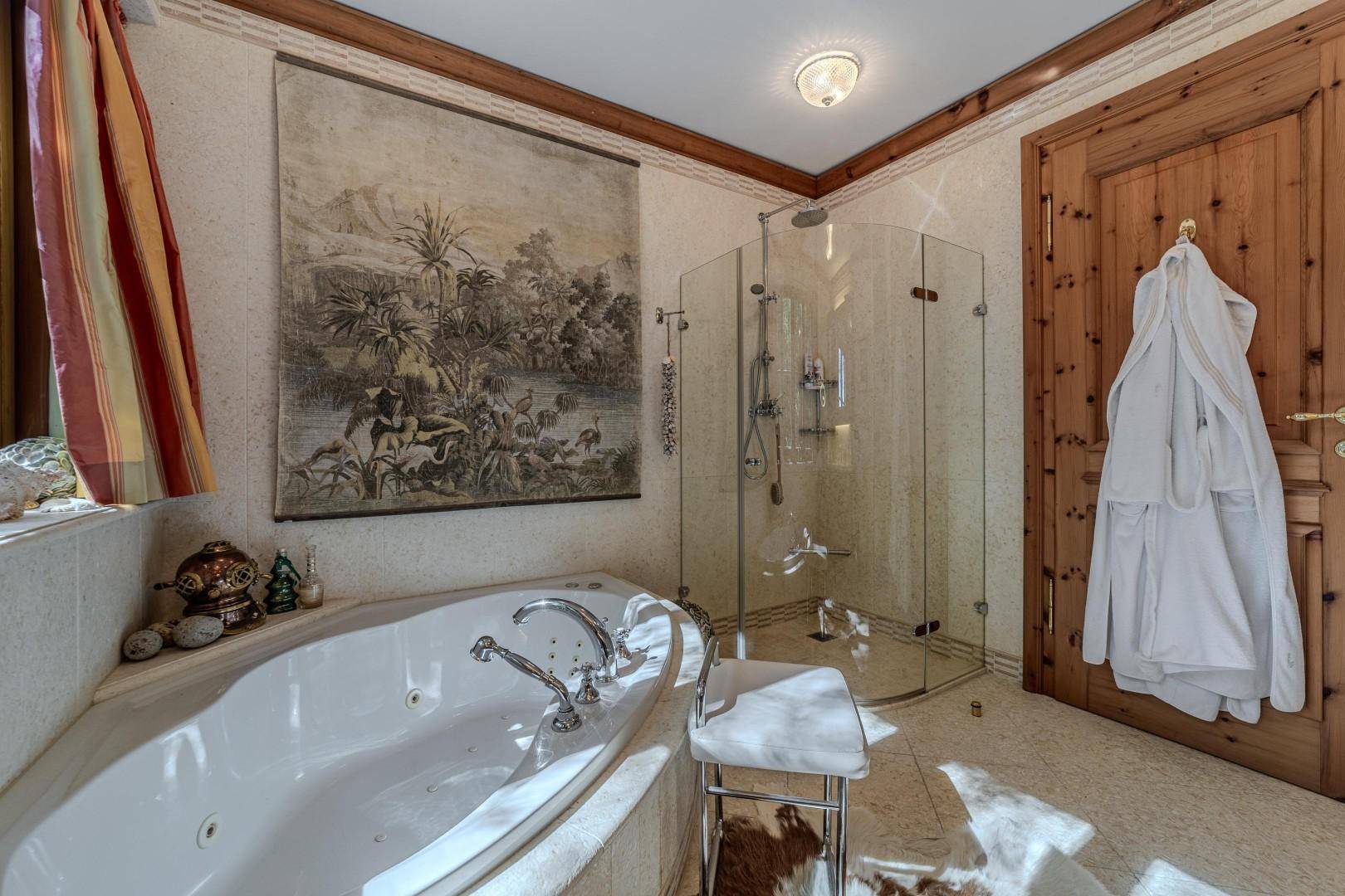 Helles Badezimmer mit Eckbadewanne, Glasdusche und traditioneller Wanddekoration.