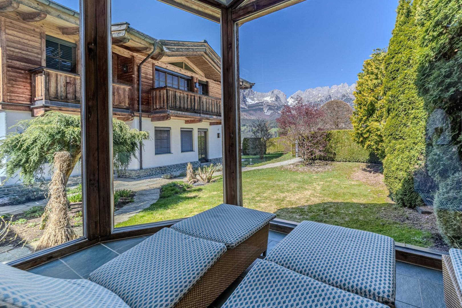 Gemütlicher Wintergarten mit Liegestühlen, bietet einen herrlichen Blick auf den Garten und die Berge.