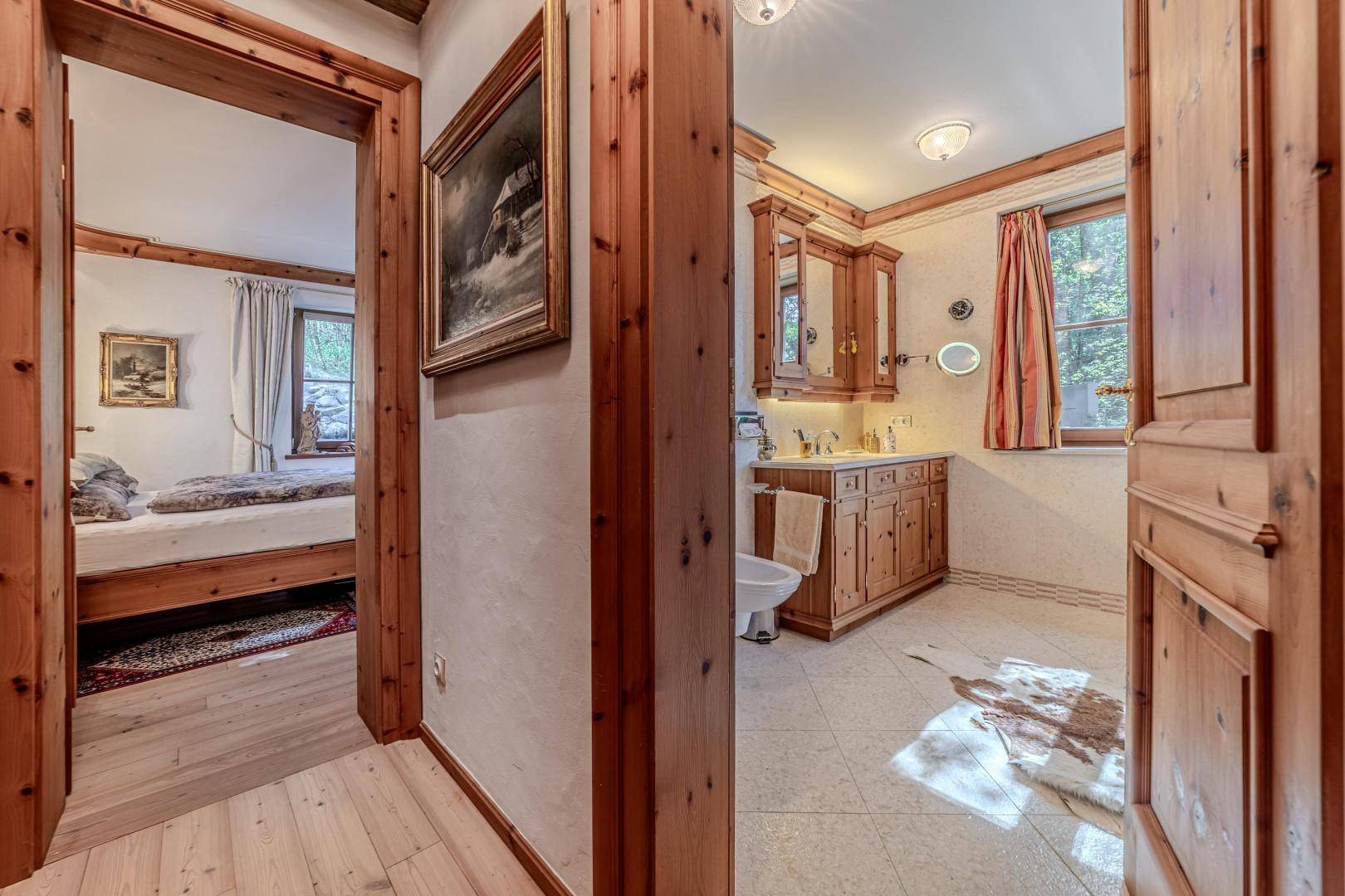 Heller Flur mit Holztüren und Blick auf ein Schlafzimmer und ein Badezimmer.