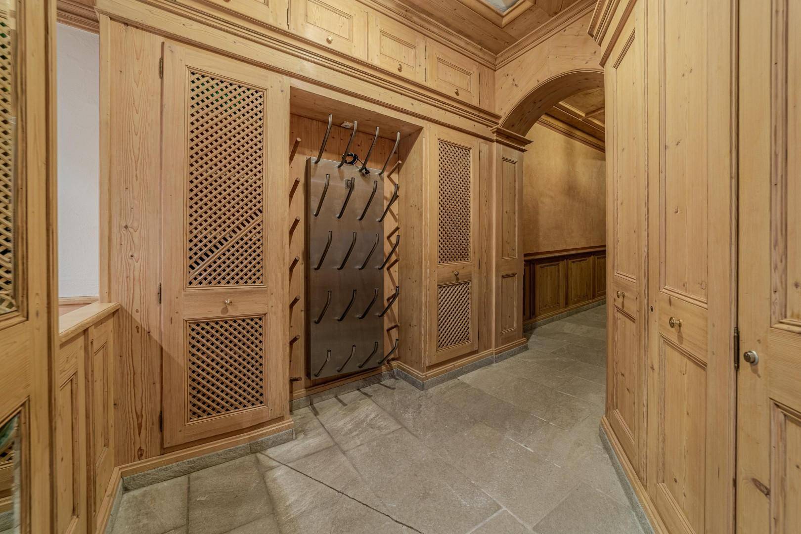 Detaillierte Ansicht der Holzschränke und des Stiefeltrockners im traditionellen Skiraum.