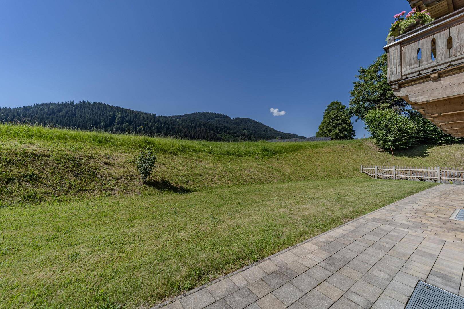 Große, offene Rasenfläche mit sanften Hügeln und Blick auf die umliegende Natur.