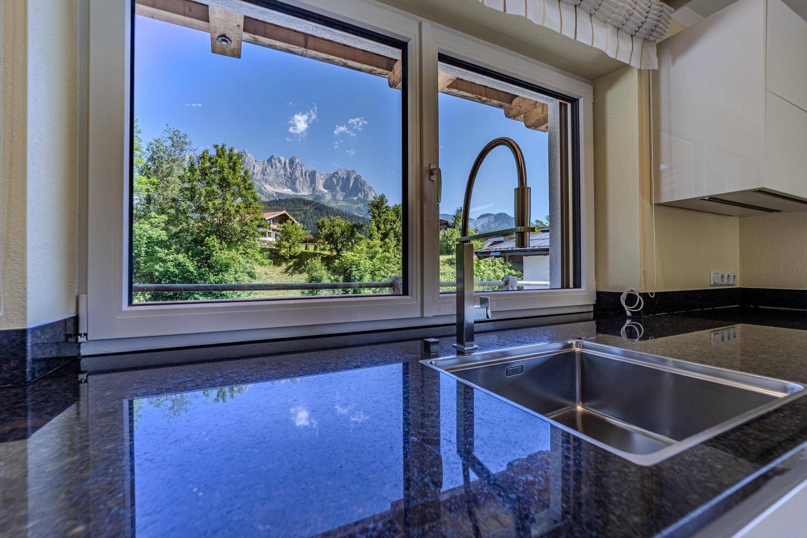 Küchenspüle mit Granitarbeitsplatte und malerischem Bergblick durch das Fenster.
