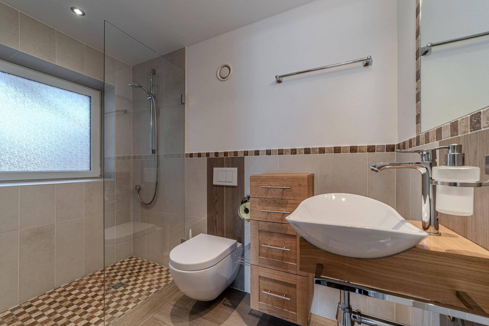 Modernes Badezimmer mit begehbarer Dusche, Wand-WC und Holzwaschtisch.