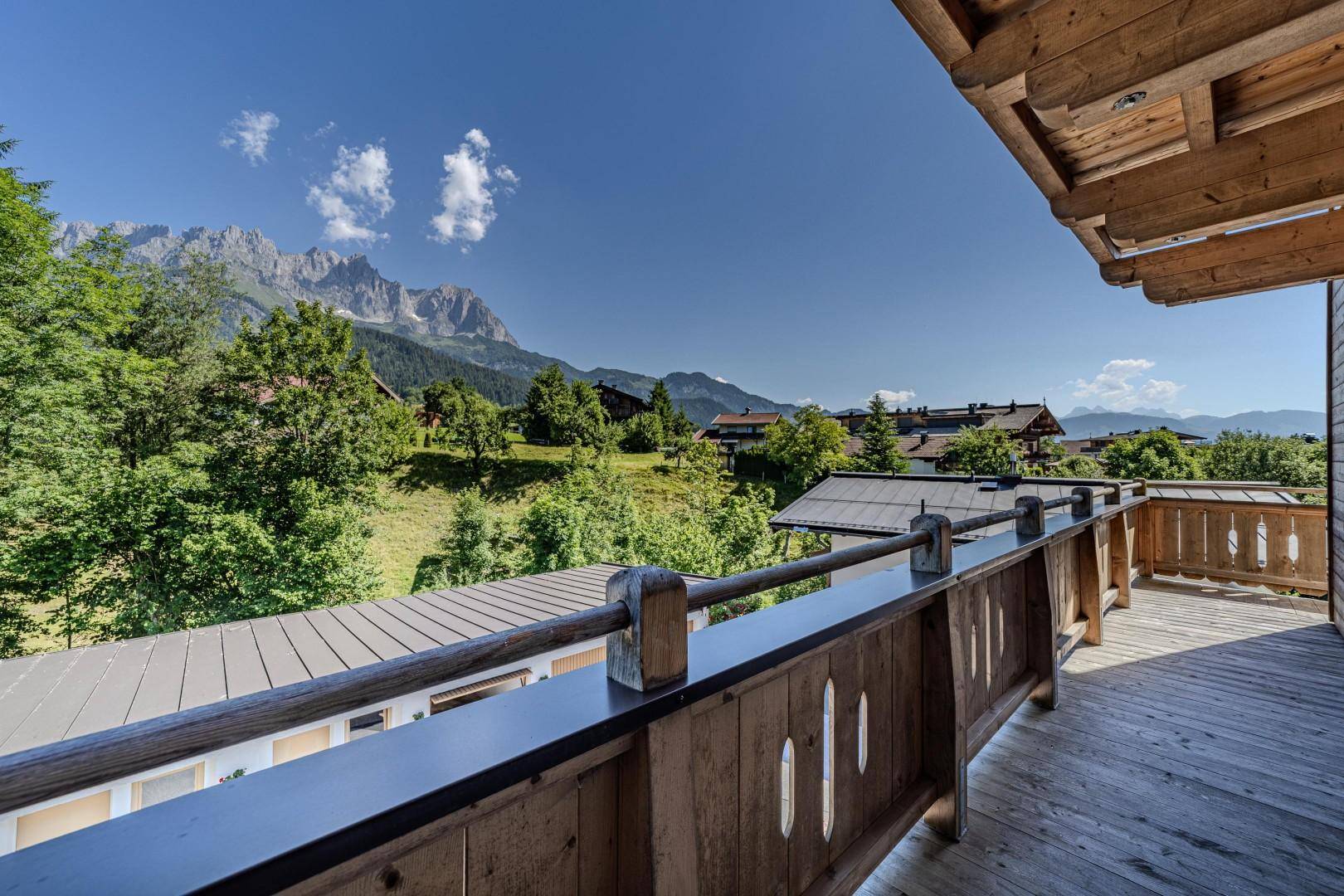 Geräumiger Holzbalkon mit Panoramablick auf die Berge und die umliegende Natur.