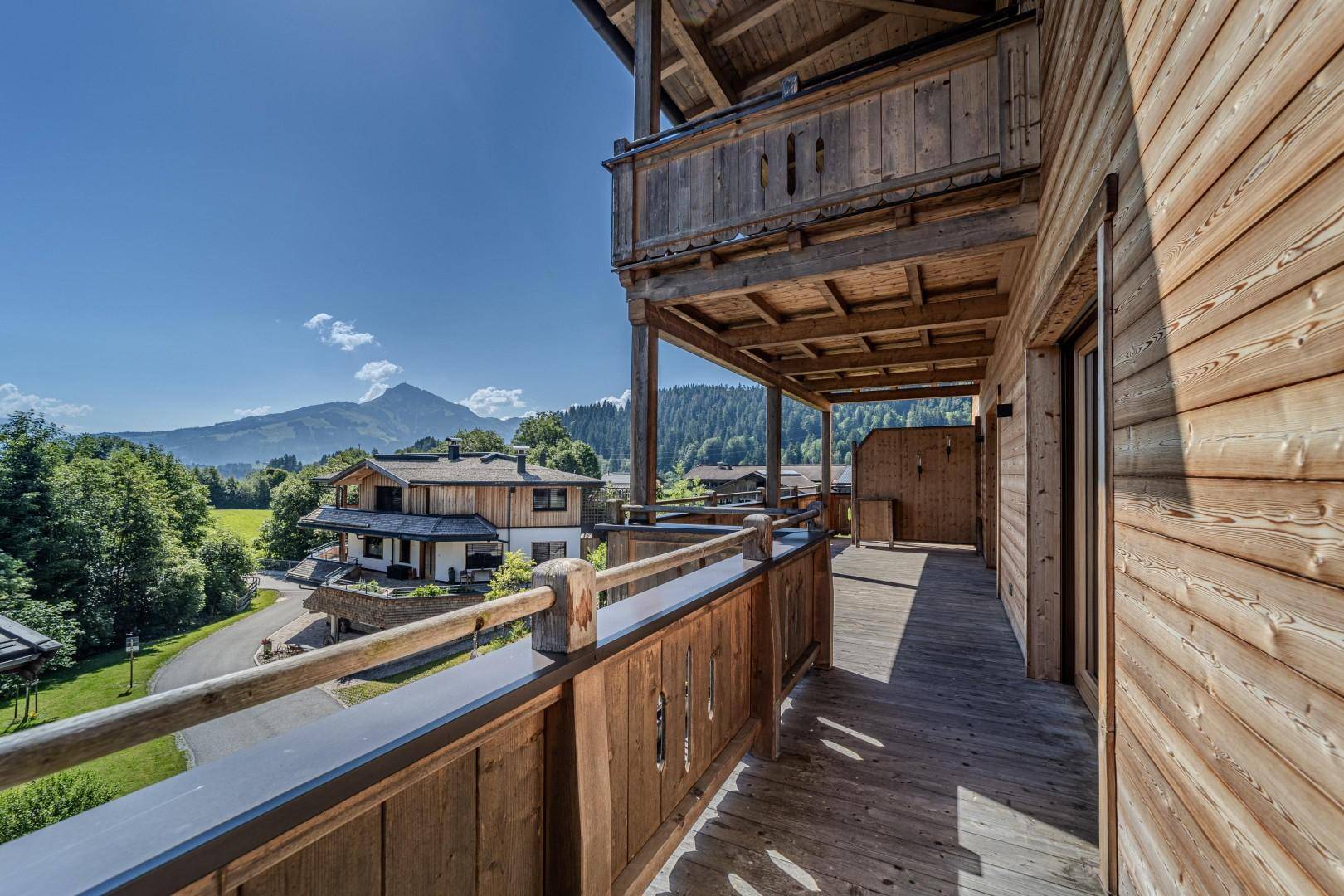 Langer Holzbalkon mit beeindruckendem Bergblick und traditioneller Architektur.