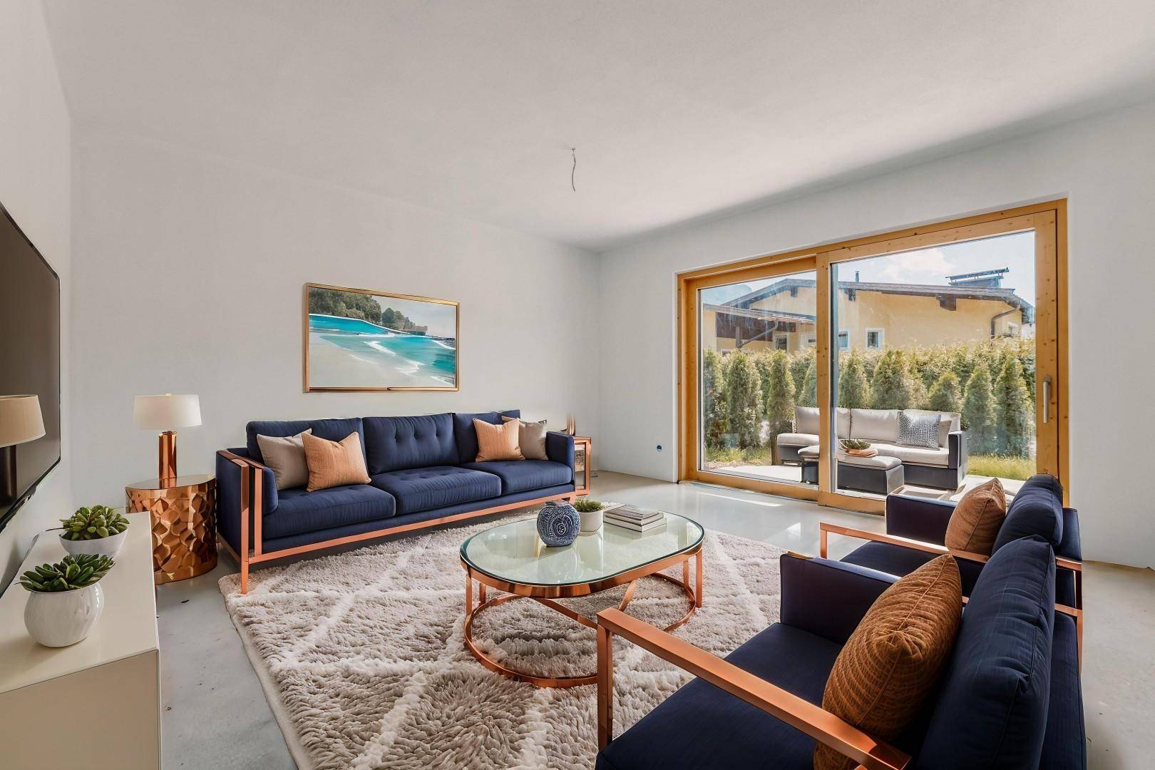Gemütliches Wohnzimmer mit blauen Sofas, modernem Teppich und direktem Zugang zur Terrasse.