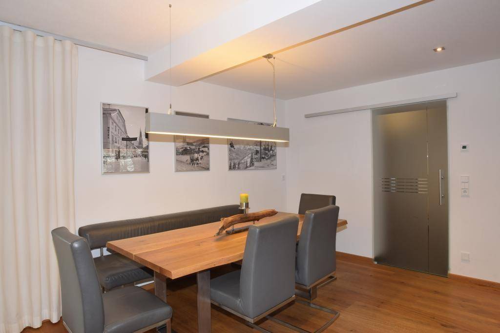 Gemütlicher Essbereich mit Holztisch, Sitzbank und Schiebetür aus Milchglas.