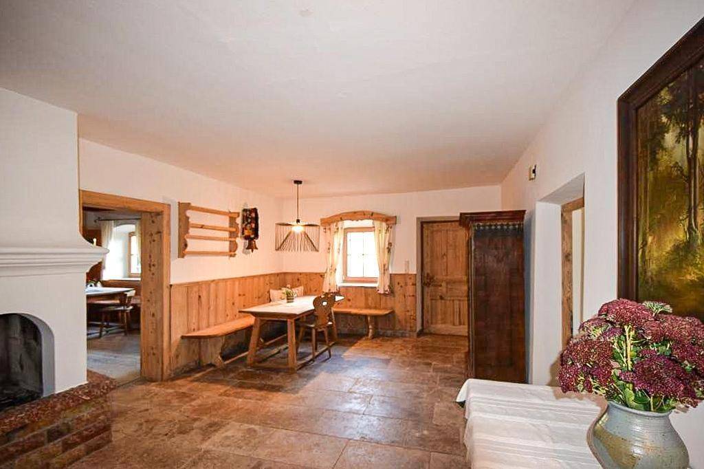 Gemütlicher Eingangsbereich mit Kamin, Steinfliesen und traditionellen Holzbänken.