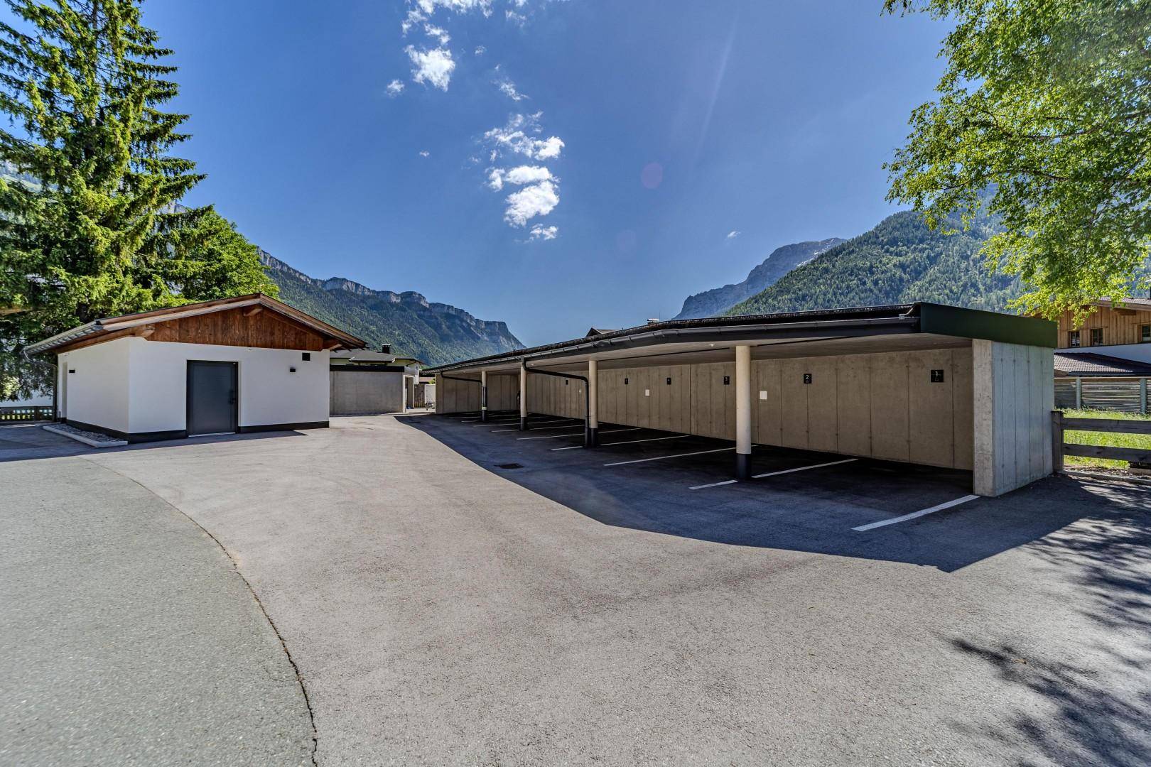 Reihe von überdachten Carports und ein kleines Nebengebäude mit Blick auf die umliegenden Berge.