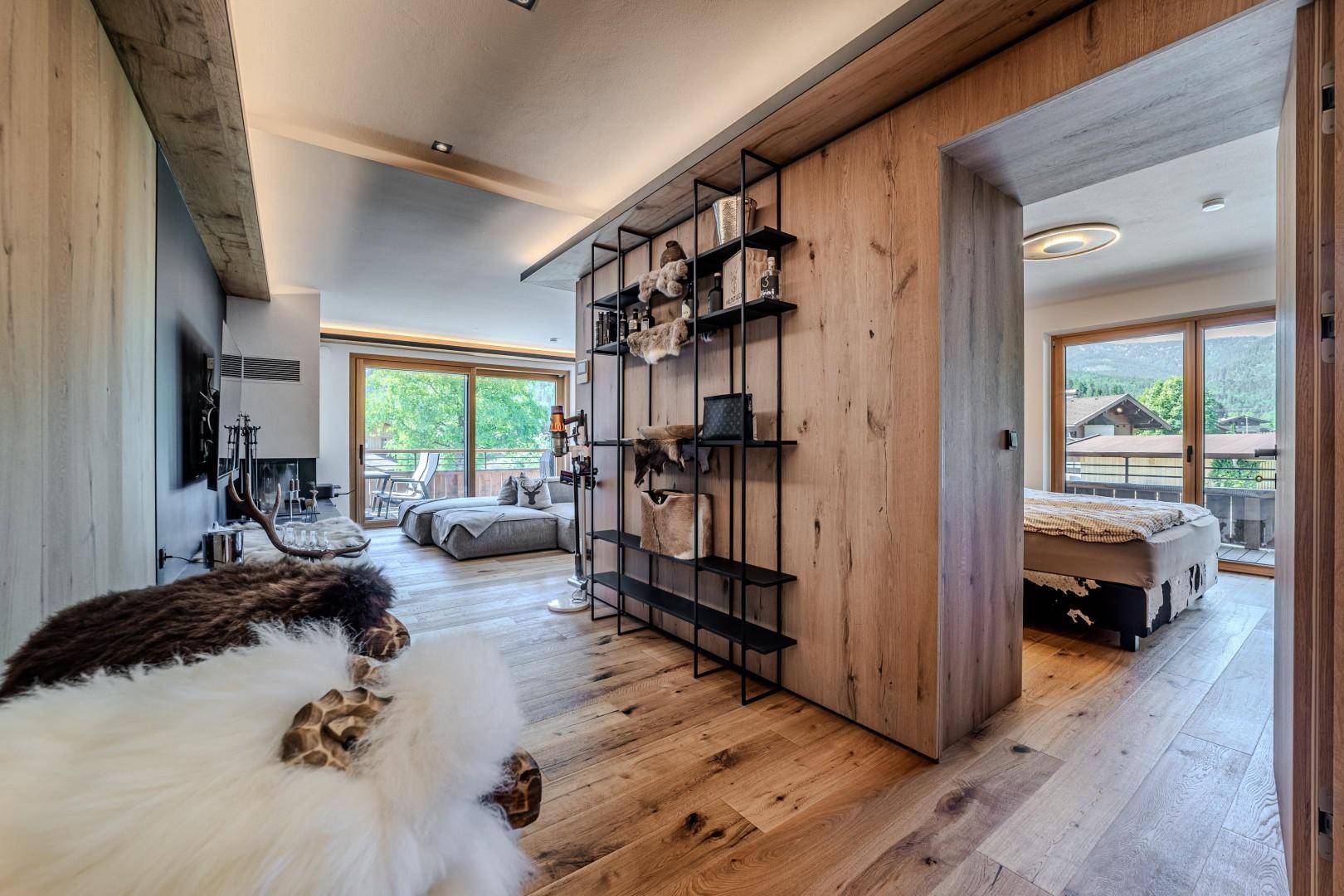 Flur mit Holzboden und offenem Regal, der zu einem Schlafzimmer führt.
