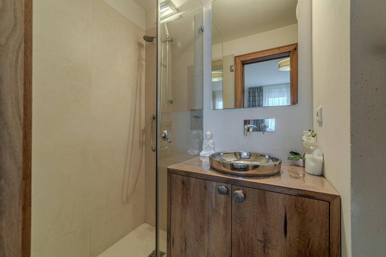Modernes Badezimmer mit begehbarer Dusche, Holzwaschtisch und rundem Aufsatzwaschbecken.