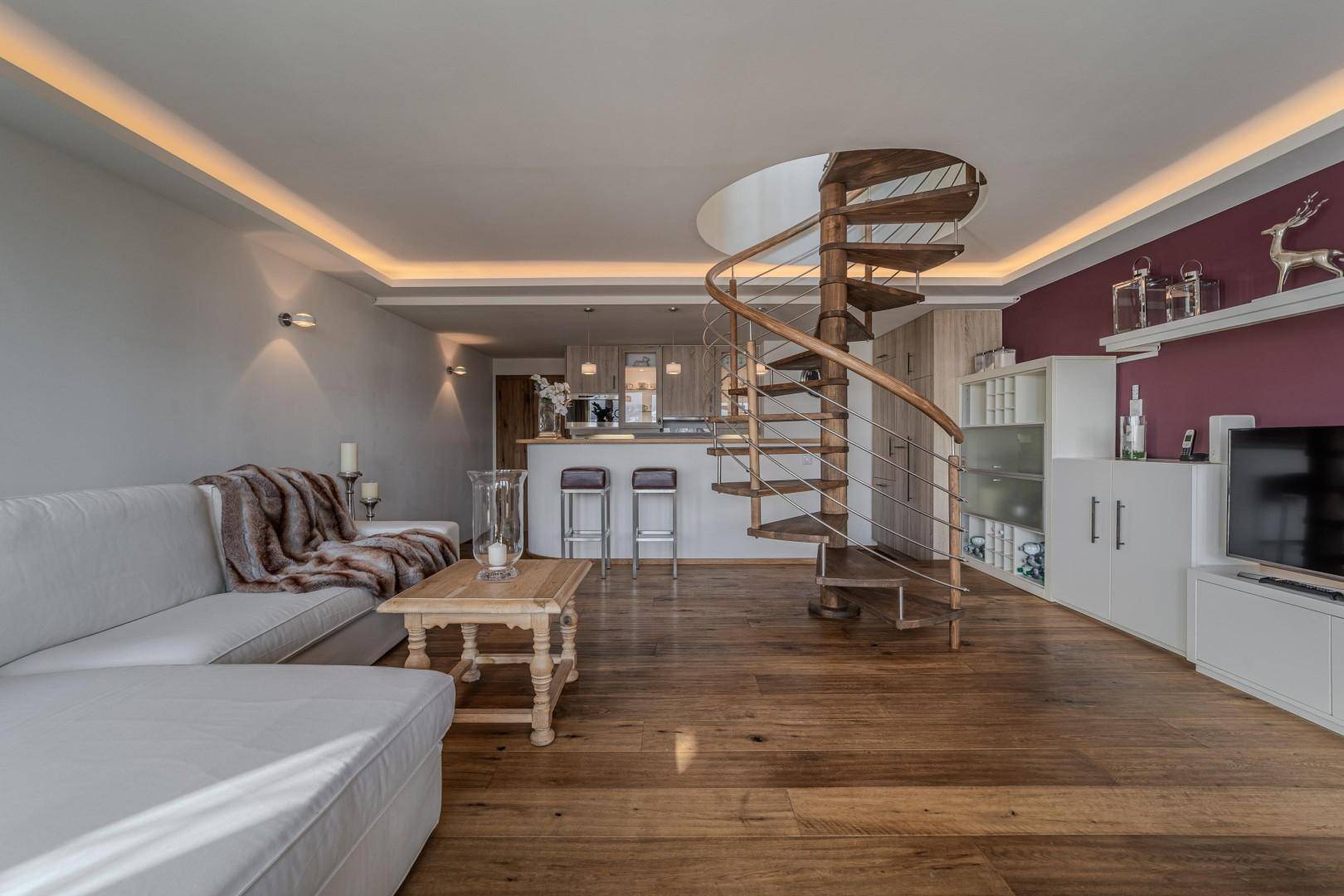 Großzügiger Wohn- und Essbereich mit Wendeltreppe, Holzboden und moderner Einrichtung.