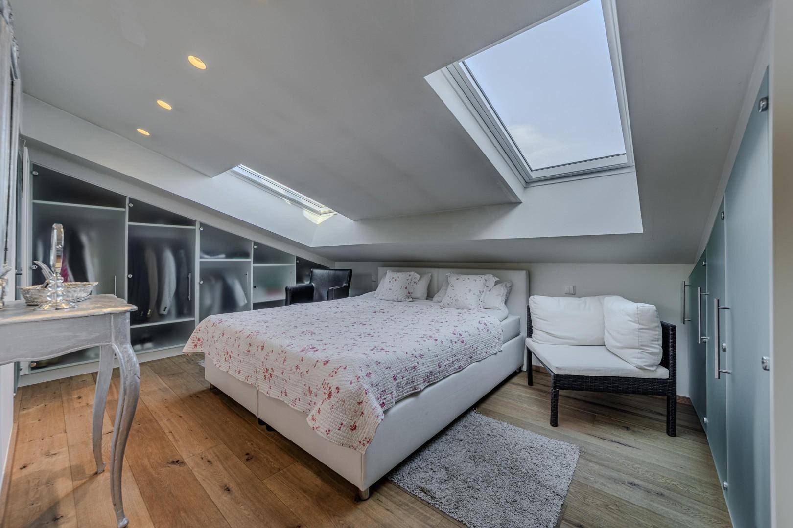 Gemütliches Schlafzimmer im Dachgeschoss mit Doppelbett, Holzboden und zwei Dachfenstern für viel Licht.