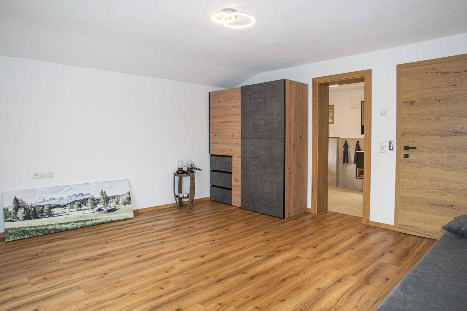 Helles Schlafzimmer mit Laminatboden und modernem Kleiderschrank, bereit zur individuellen Gestaltung.