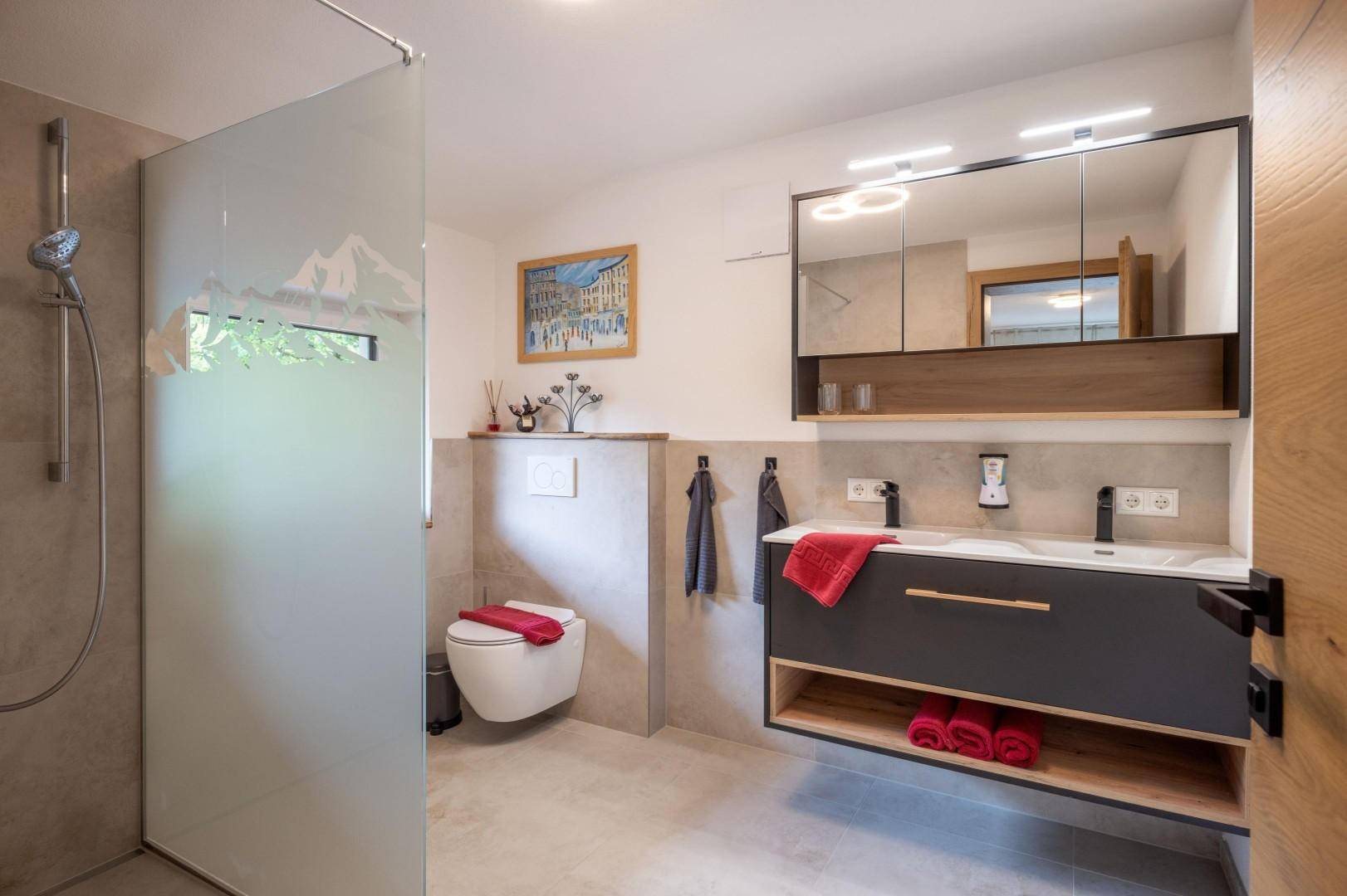 Modernes Badezimmer mit begehbarer Dusche, Wand-WC und stilvollem Waschtisch mit Unterschrank.