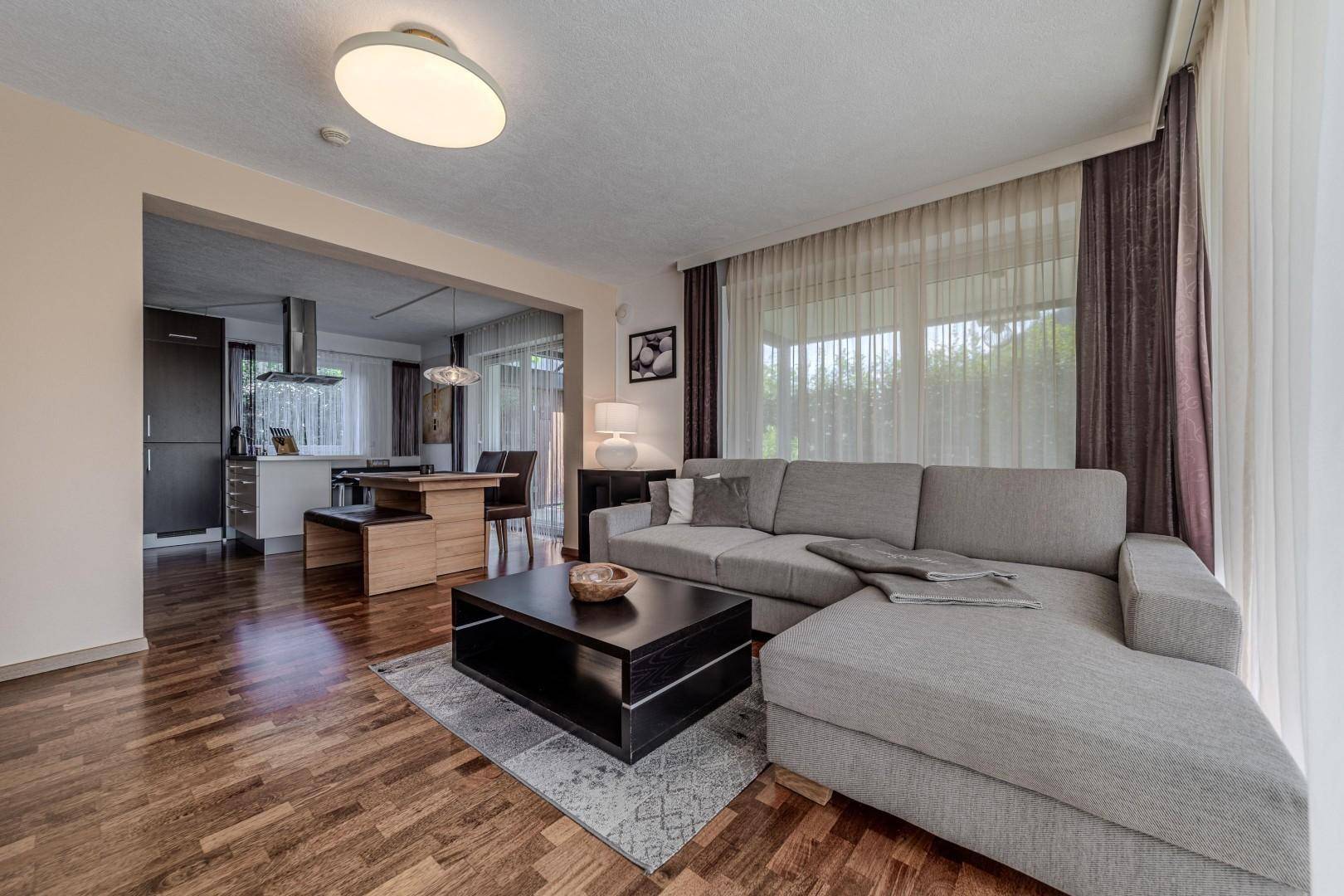 Geräumiger Wohnbereich mit Sofa und Blick auf die offene Küche und den Essbereich.