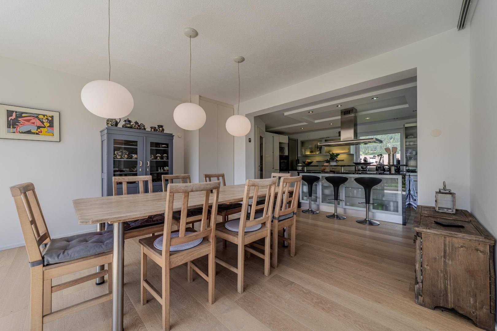 Geräumiger Essbereich mit Holztisch und Blick auf die moderne offene Küche.