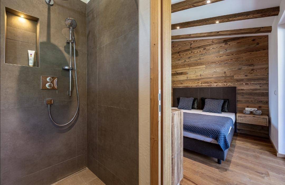 Modernes Badezimmer mit begehbarer Dusche, direkt verbunden mit dem Schlafzimmer.