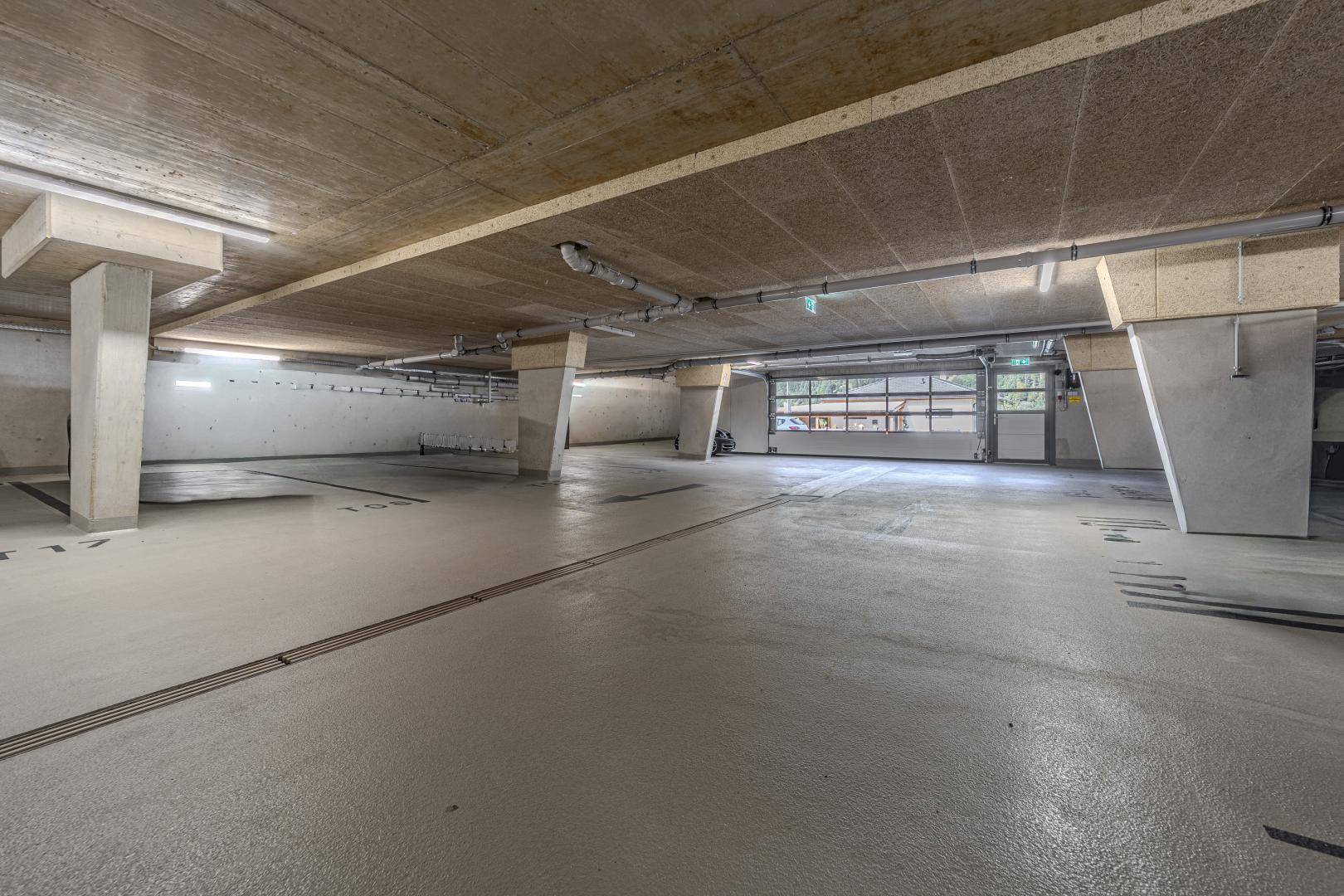 Geräumige Tiefgarage mit mehreren Stellplätzen und direktem Zugang zum Gebäude.