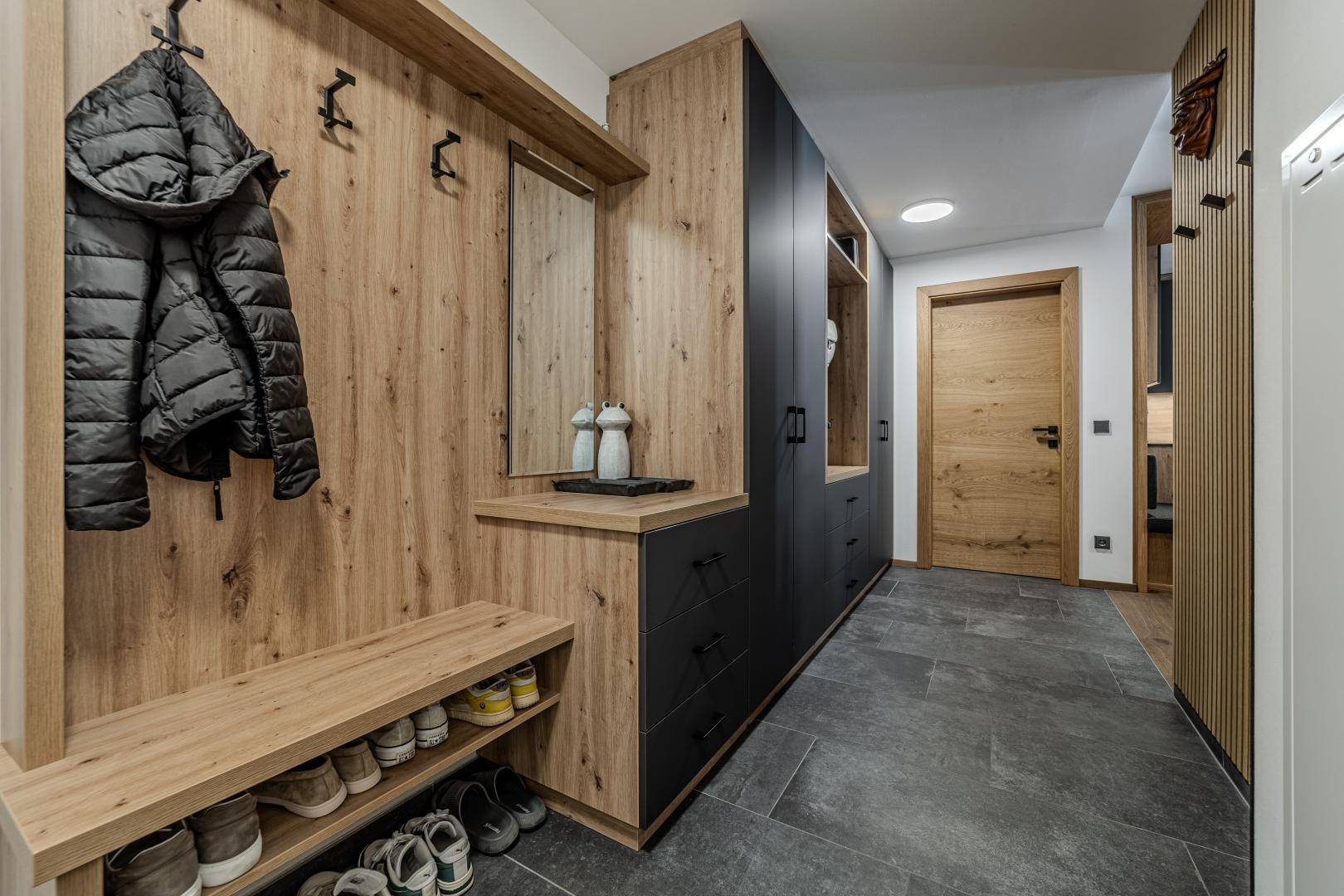 Eingangsbereich mit Garderobe, Sitzbank und Spiegel, bietet praktischen Stauraum.