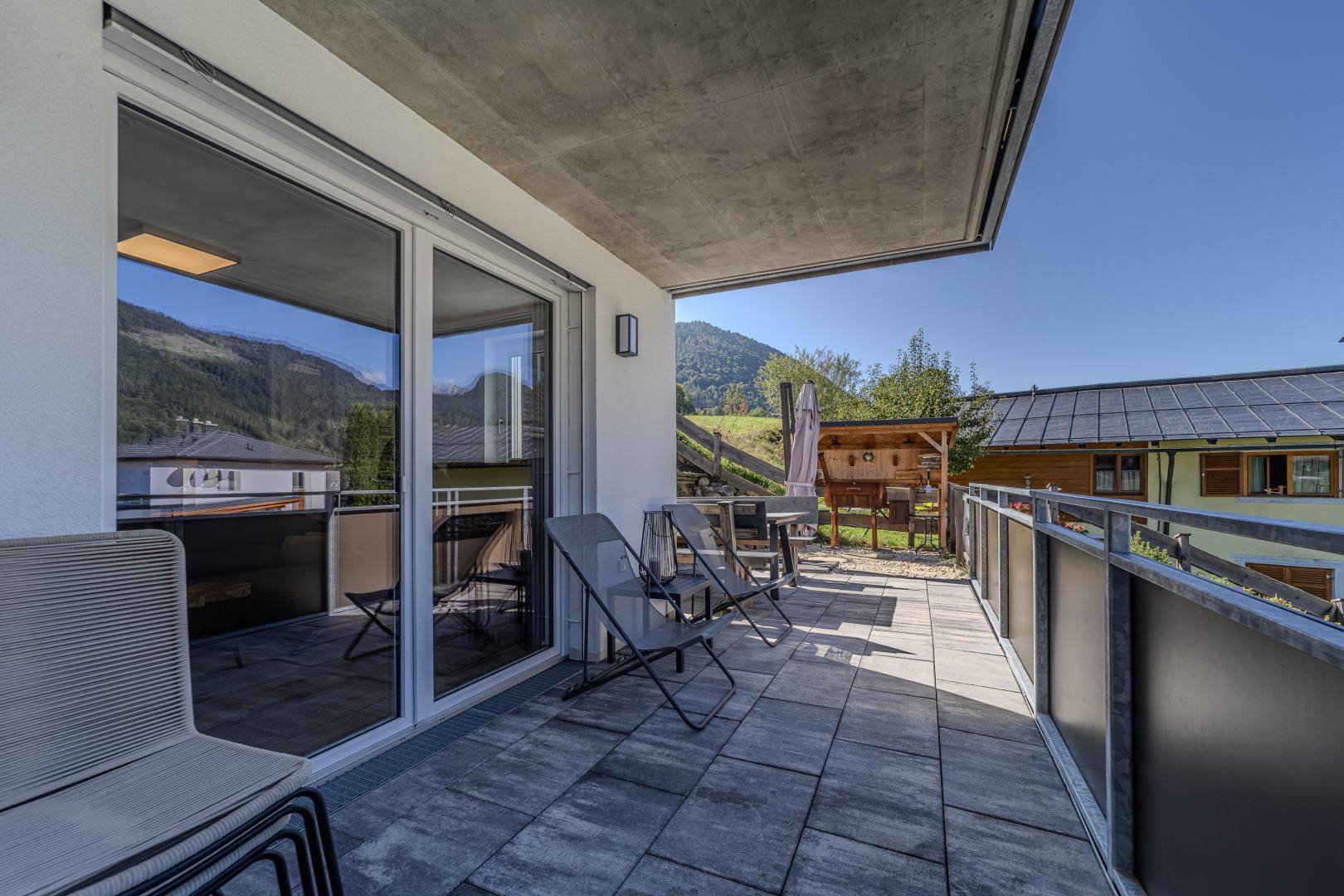 Großer Balkon mit Fliesenboden und Bergblick, ideal für Entspannung im Freien.