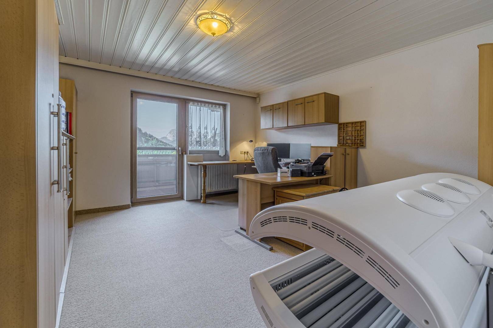 Geräumiges Büro mit Schreibtisch, Büromöbeln und Solarium.